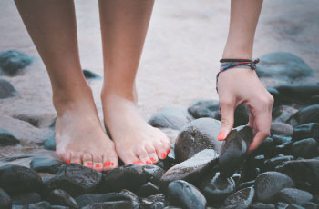 girl picking up rocks on a beach